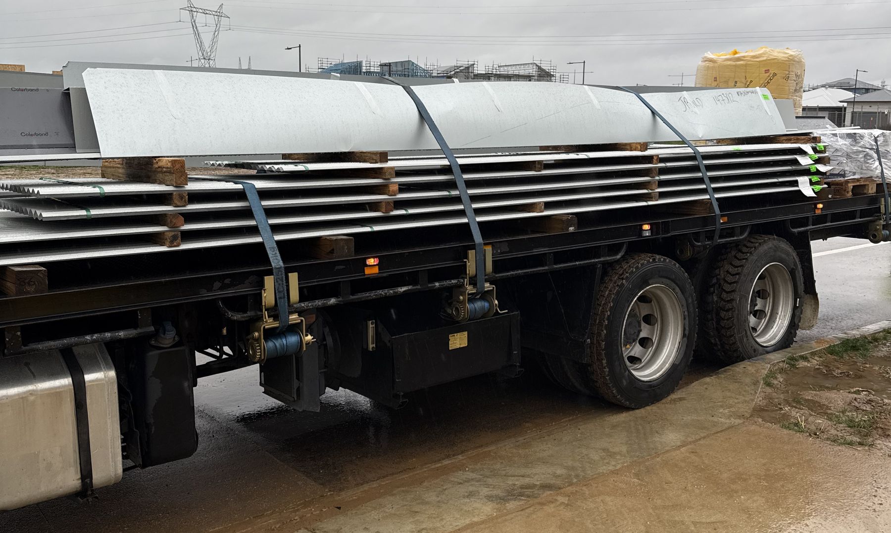 Crane truck loaded with roofing sheets for delivery