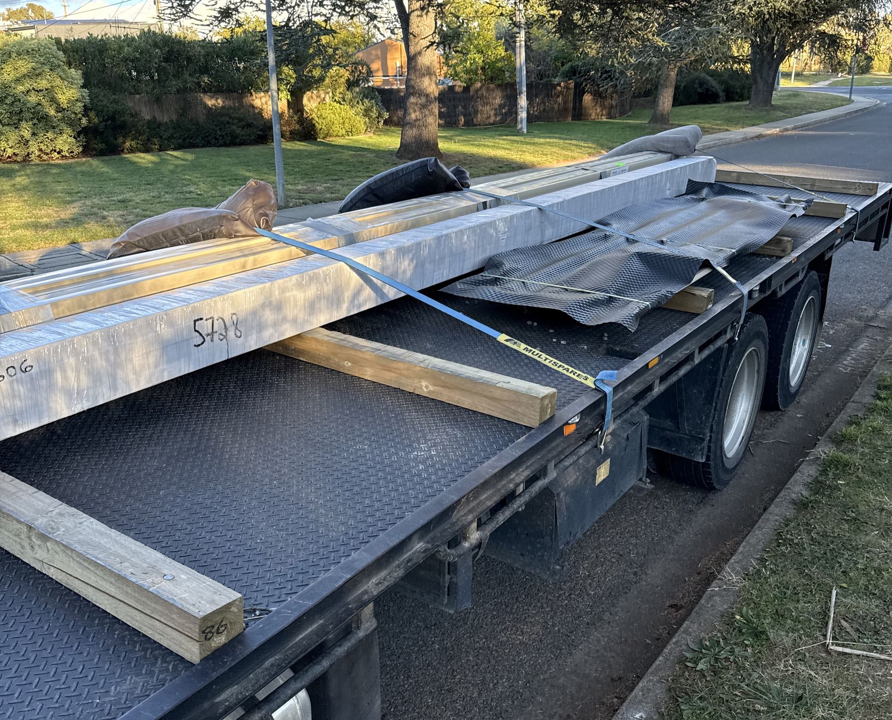Long beams strapped on a crane truck tray