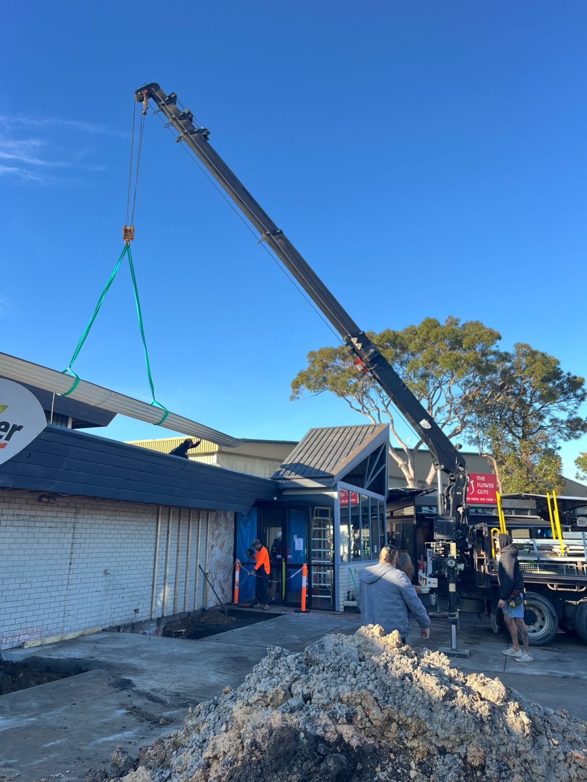 Crane lifting roofing material onto a building